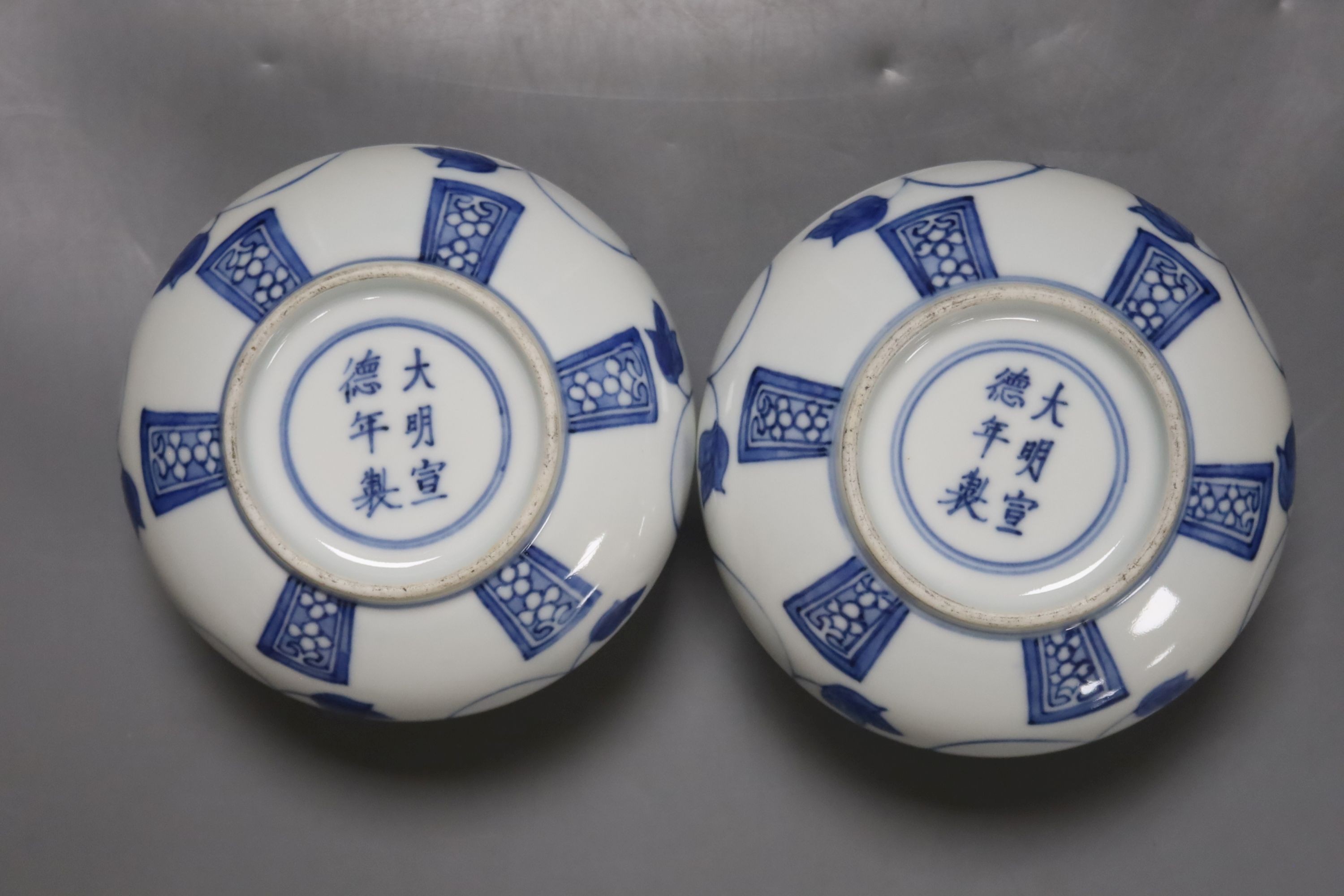 A pair of Chinese blue and white jars and covers, 6.5cm, on wood stands, a Chinese blue and white bowl and two small enamelled wine cups